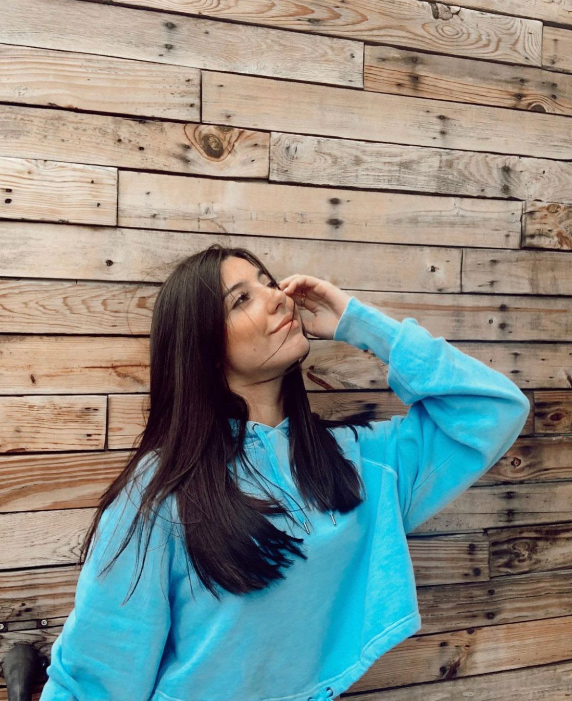 Foto de Paola Díaz Álvarez frente a una pared de madera. 