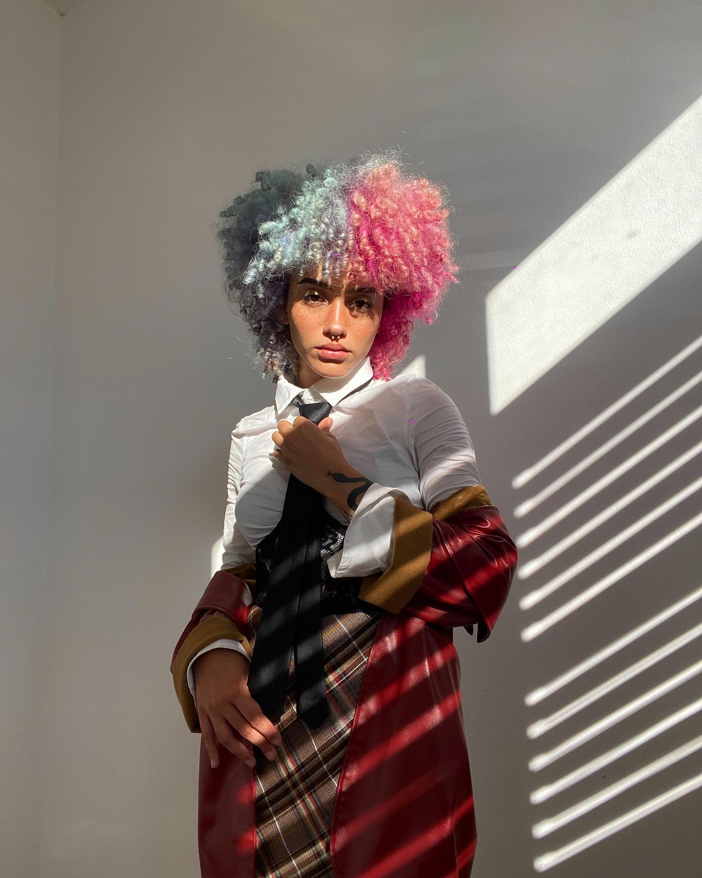 Retrato de Joan Correa Santiago. Se encuentra posando frente a una pared blanca. 